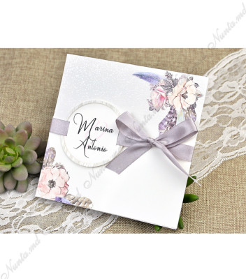 <p>Invitație de nuntă cu imprimeu floral. Cartonașul invitației se pliază în două părți pe verticală iar pe partea din spate este imprimat textul invitației. Coperta invitației este decorată cu o panglică de mătase gri și o etichetă pe care se printează numele mirilor. În prețul invitației este inclus plic.</p>